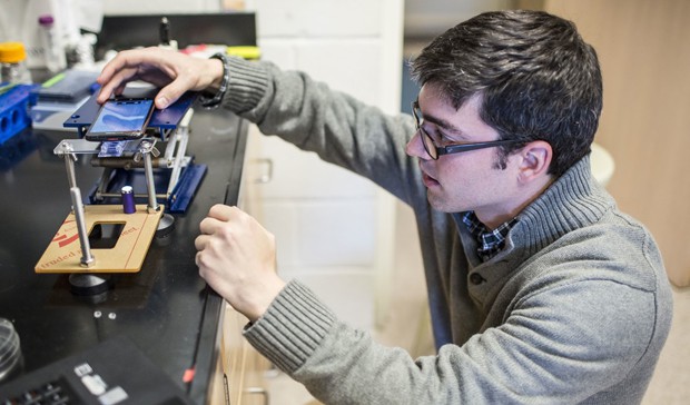 Emory post-doctoral fellow Kevin Yehl sets up a smart-phone microscope to get a readout for the particle motion of the rolling DNA-based motor (Photo by Bryan Meltz, Emory Photo/Video).
